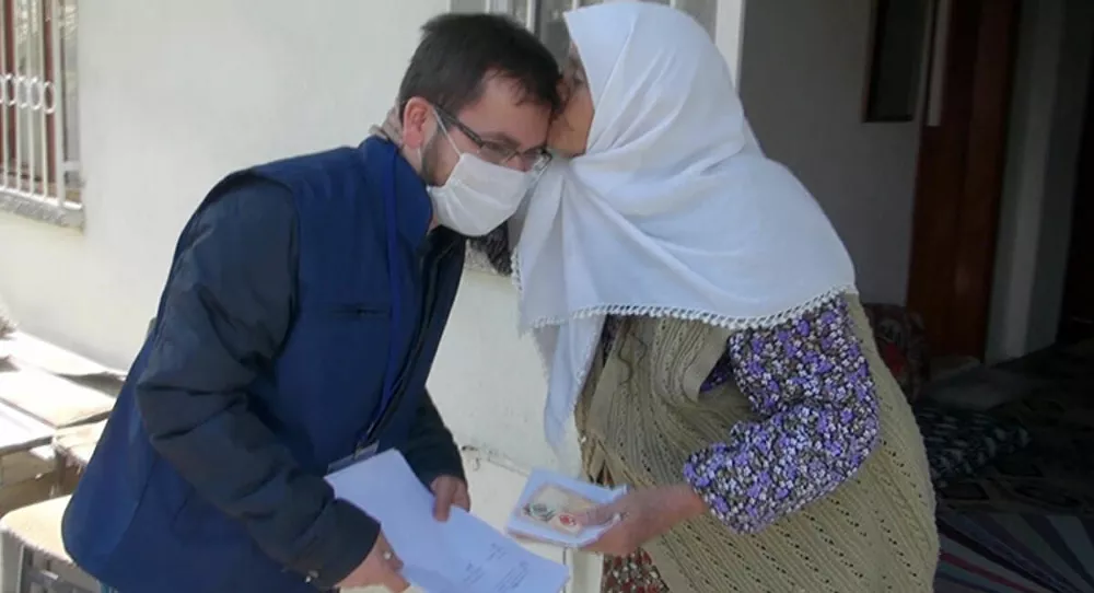 Koronavirüs nedeniyle evden çıkamayan yaşlı kadın, maaşını getiren görevliyi alnından öptü